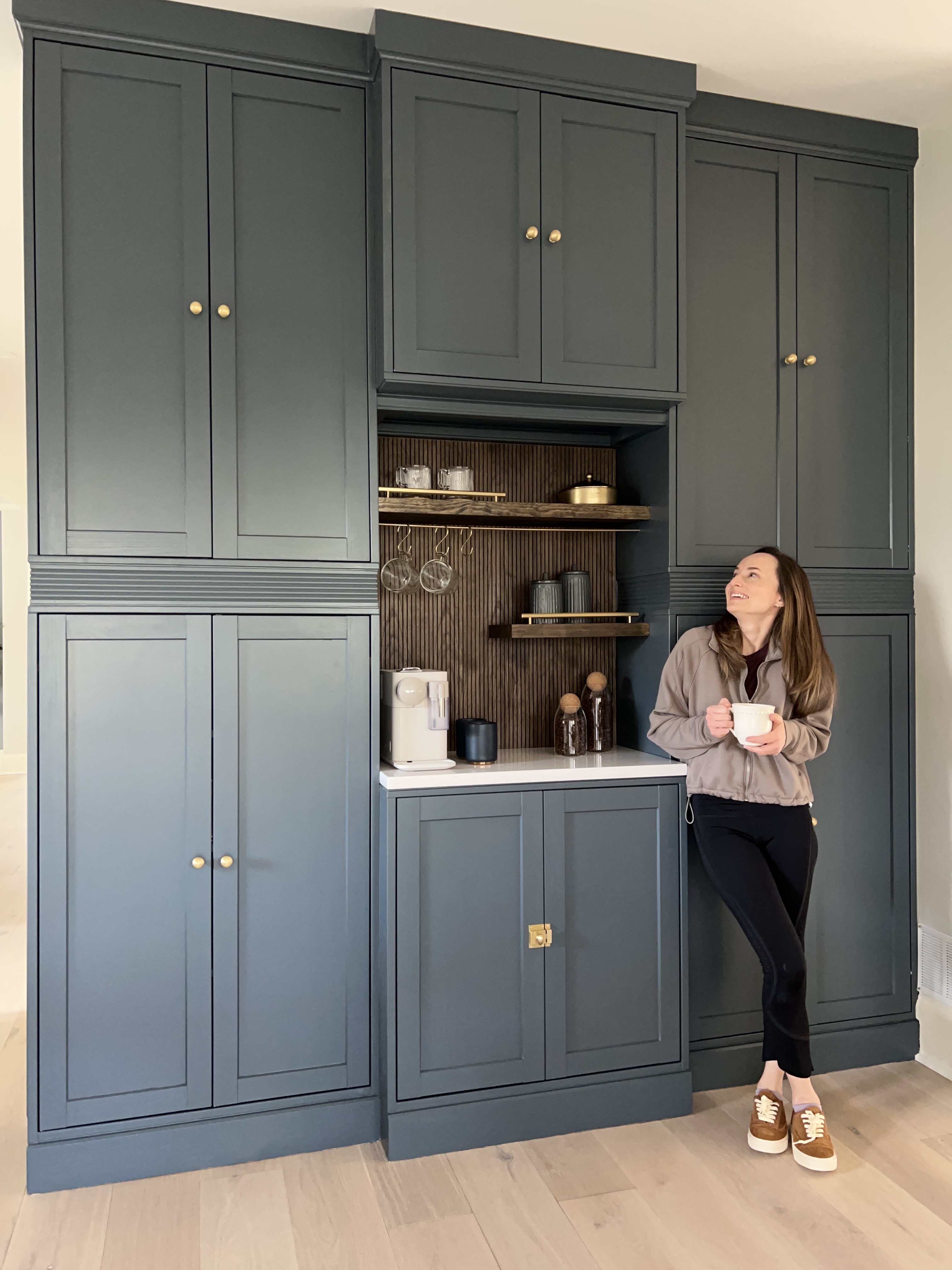 Woman standing in front of coffee nook made with ikea havsta cabinets.