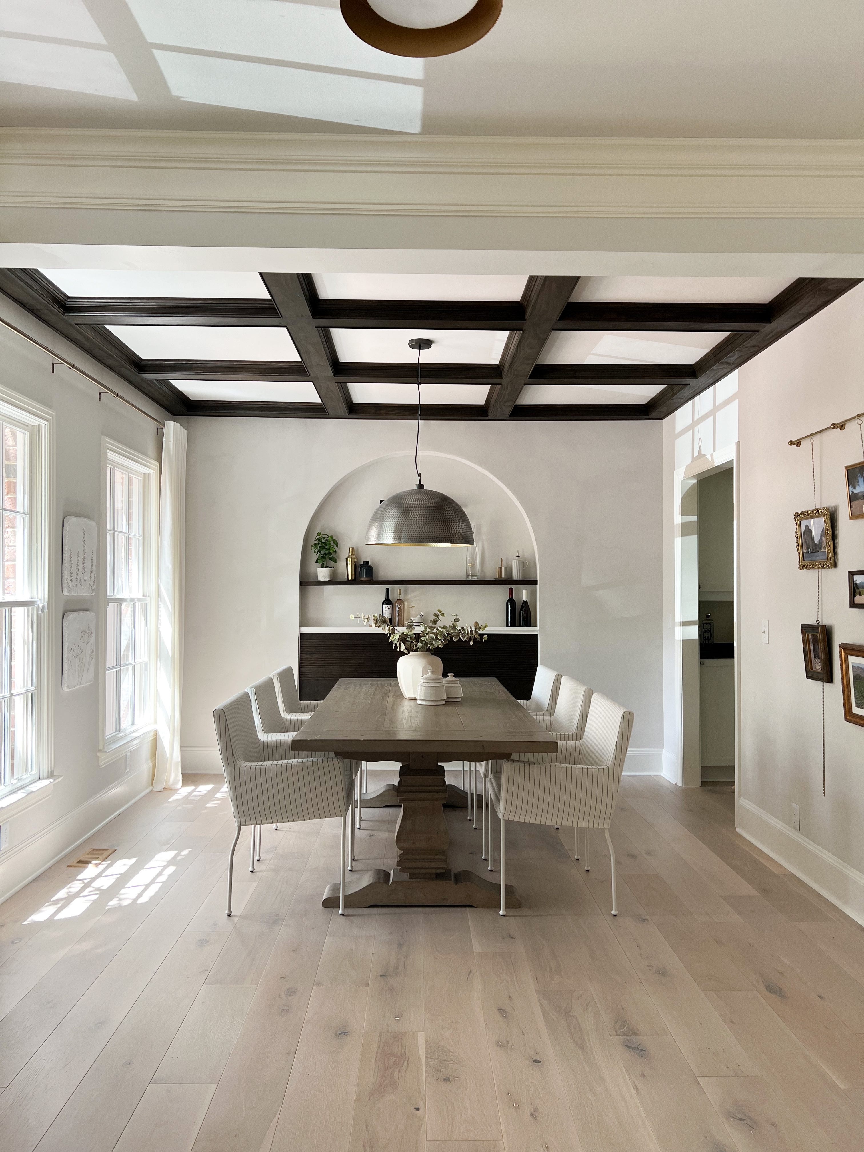 Image of a dining room with light oak floors, roman clay walls, and a dark wood diy coffered ceiling.