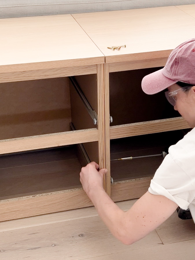 Woman screwing the IKEA Malm nightstands together.
