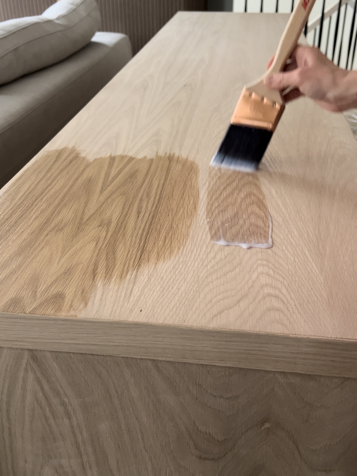 Brushing sealer on top of the diy sofa table with storage.