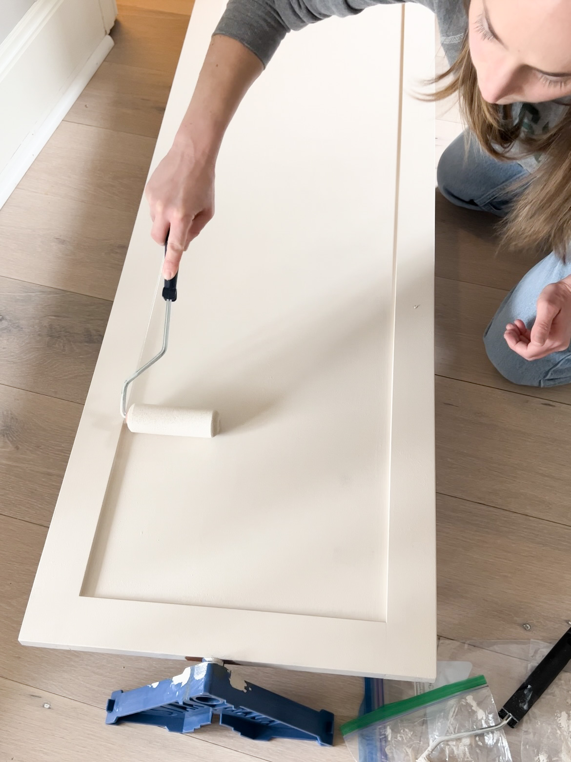 Dry rolling the cabinet door for a smooth finish.