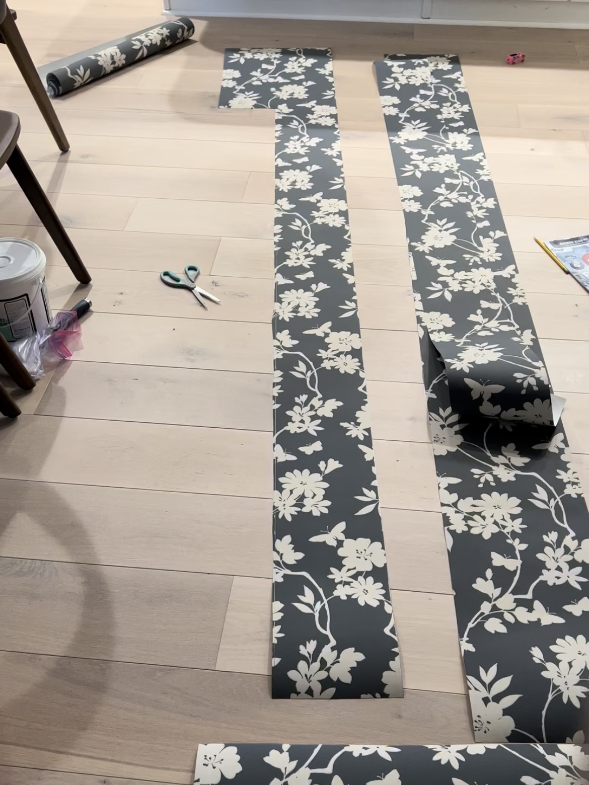 Strips of wallpaper on a floor.