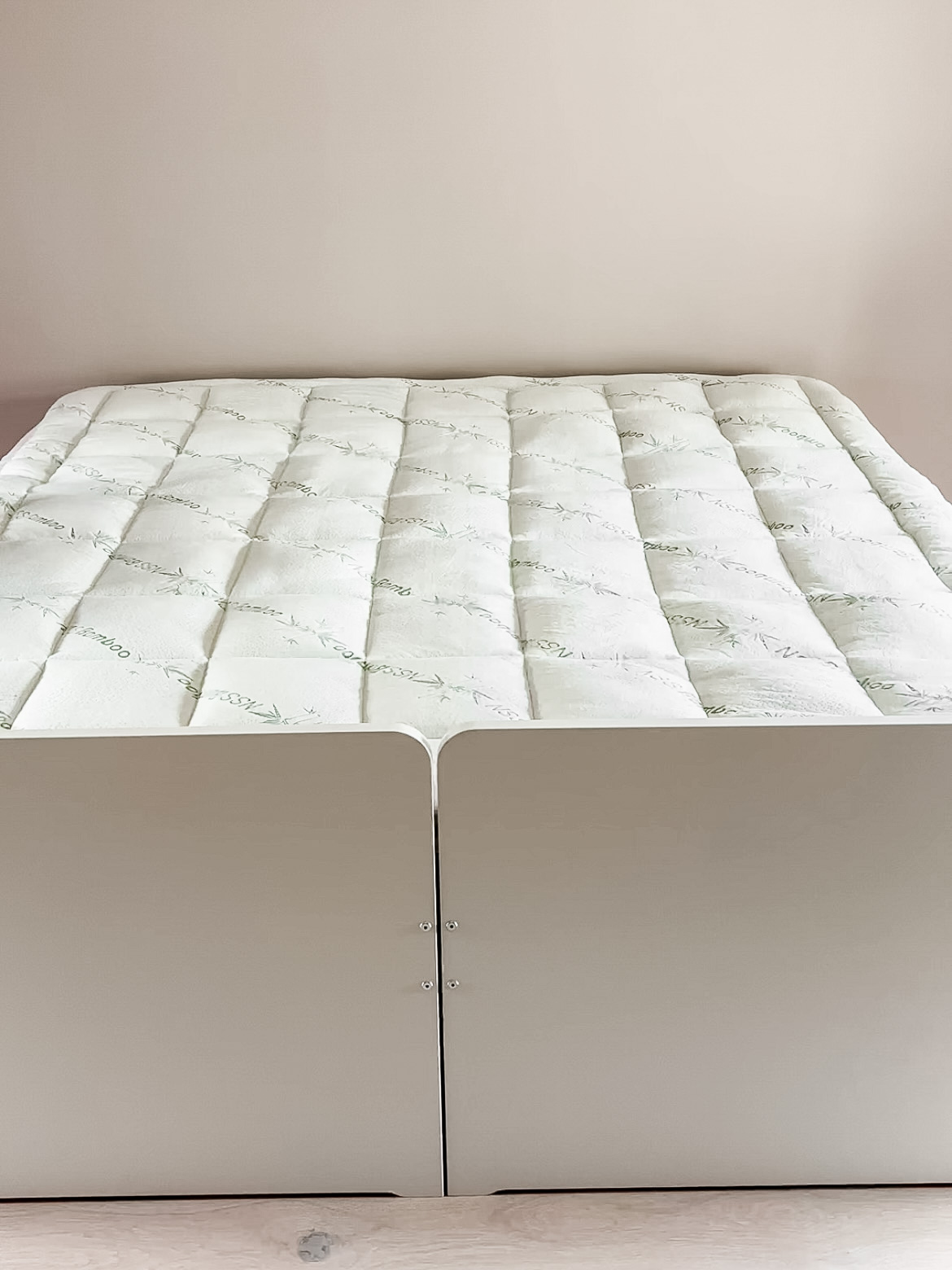 A bed with a mattress cover on top.