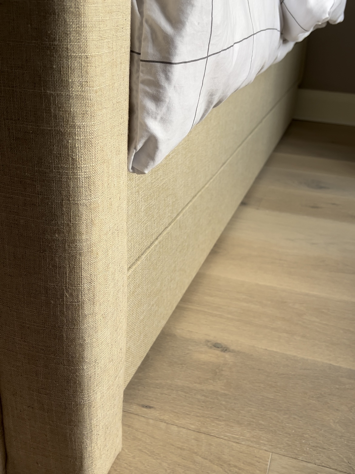 Edge of fully upholstered bed.