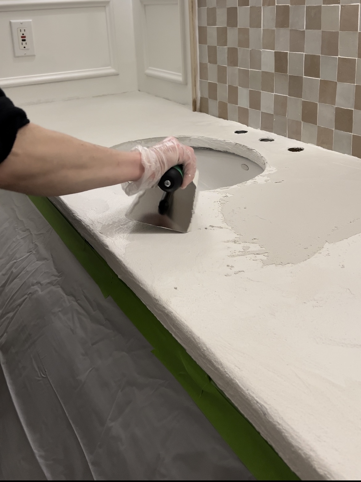 Troweling cement onto bathroom countertop.