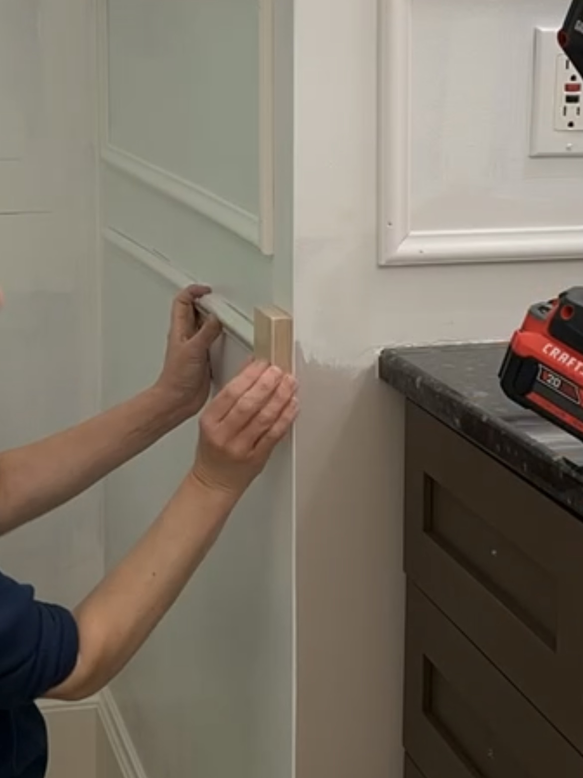 Lining up wall trim for a powder room makeover.