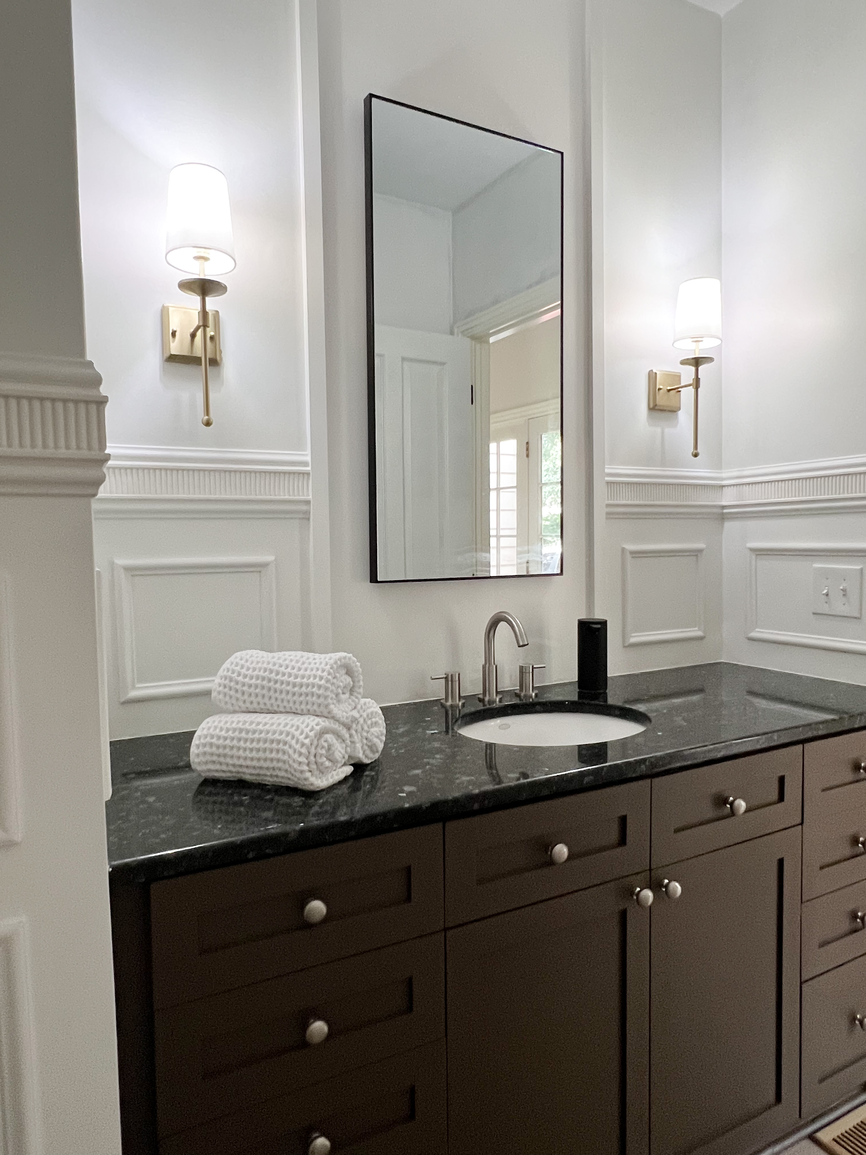 Photo of bathroom with freshly painted brown vanity.