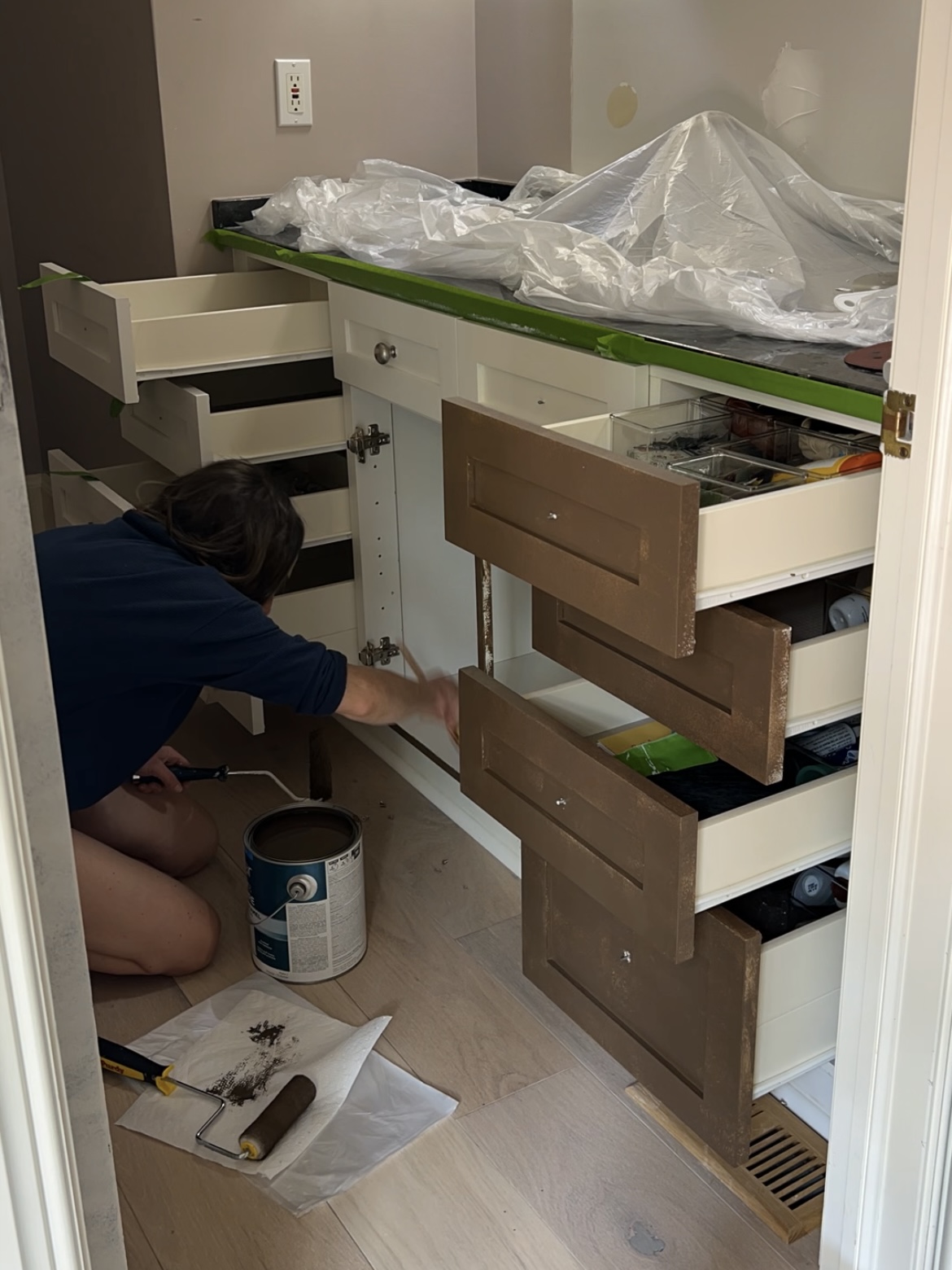 Woman painting a bathroom vanity cabinet.