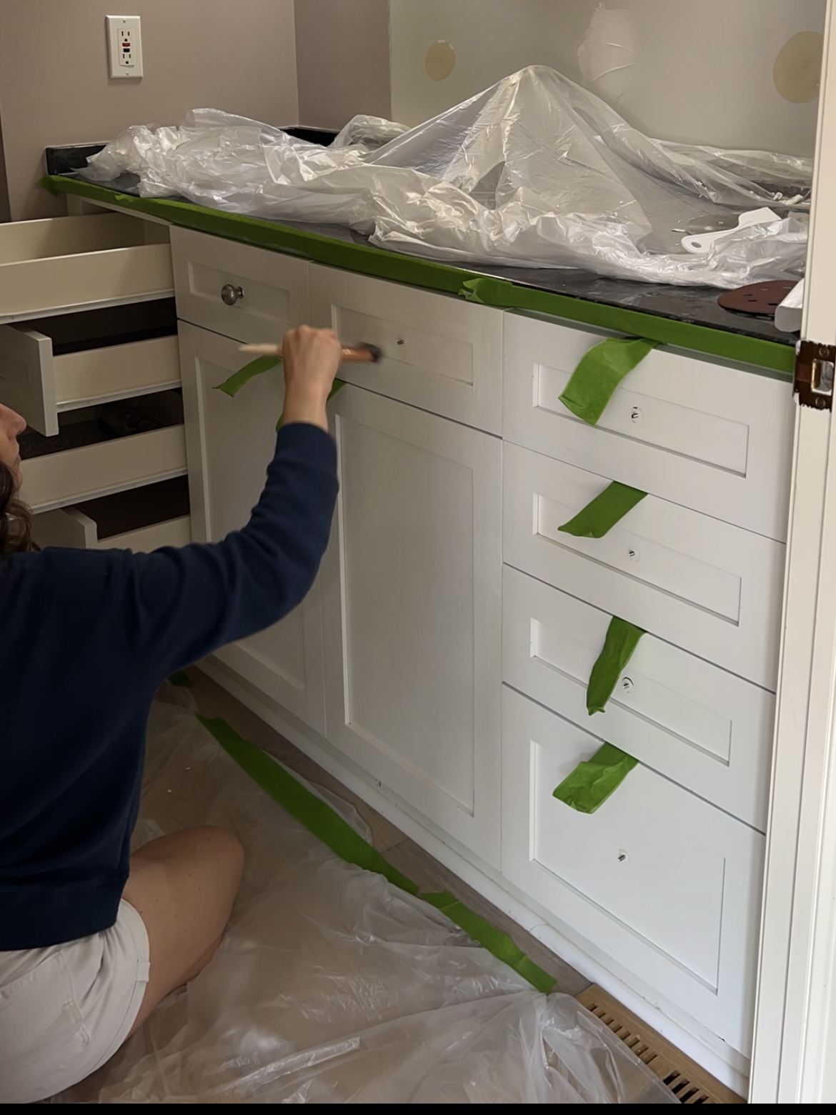 Woman priming a bathroom vanity.