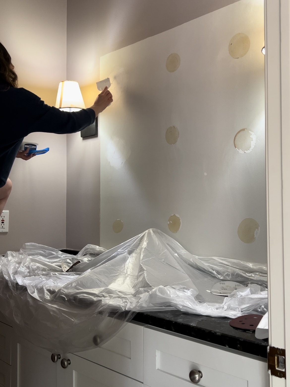 Woman patching holes in wall.