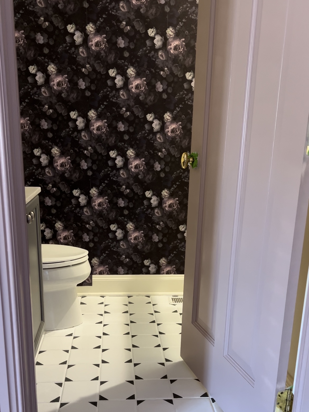 Bathroom with dark floral wallpaper.