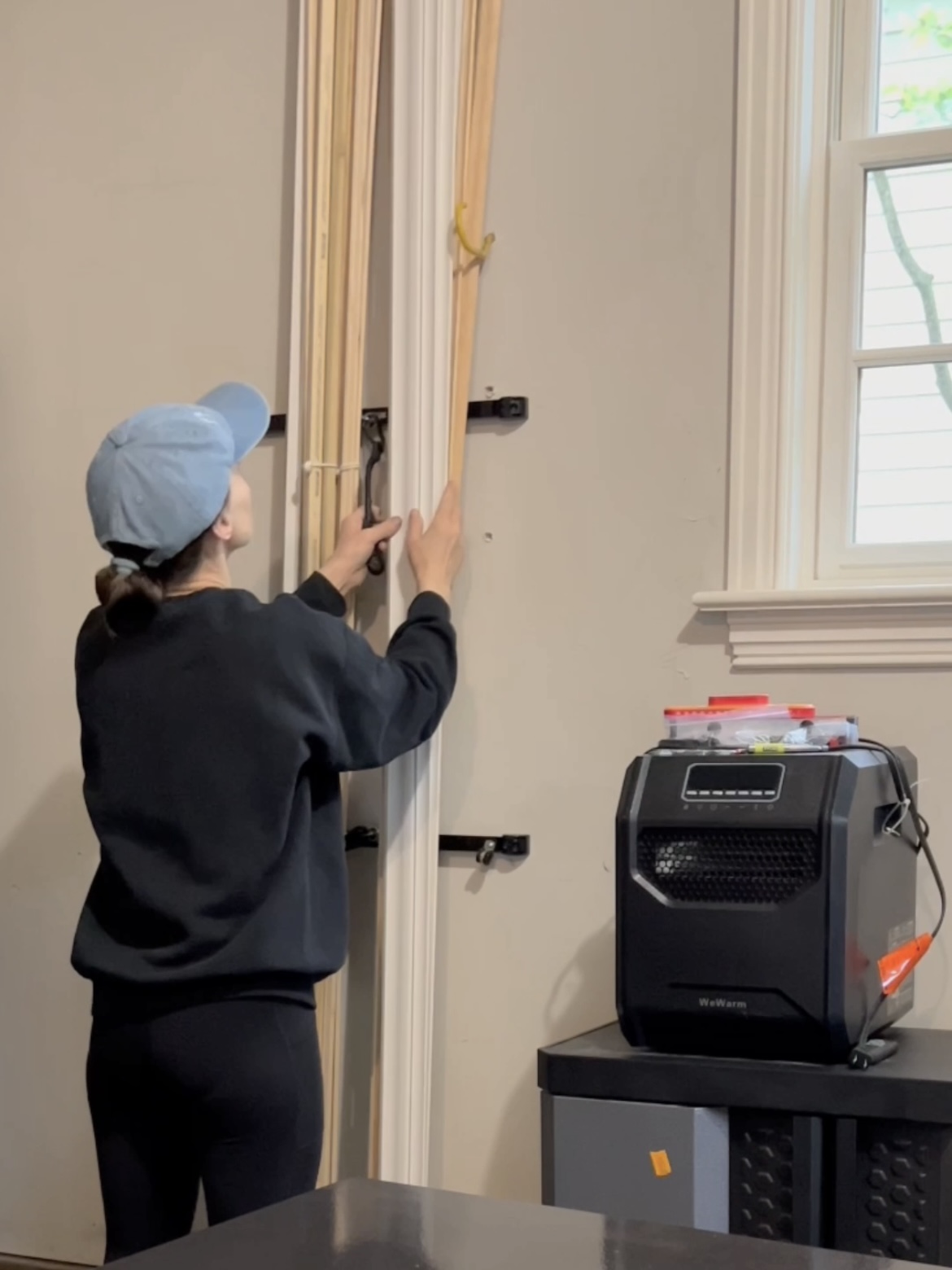 Annie securing trim pieces to wall storage.