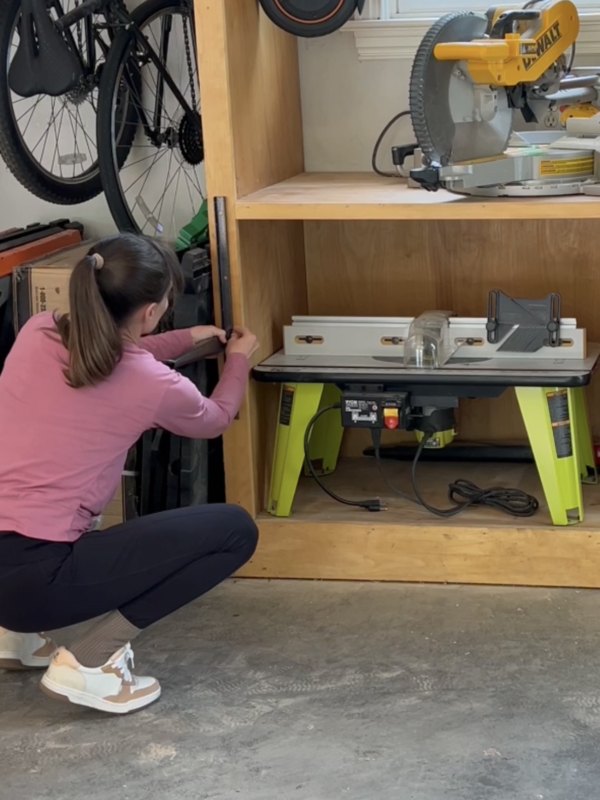 Annie attaching a bracket for wood storage to a storage cabinet.