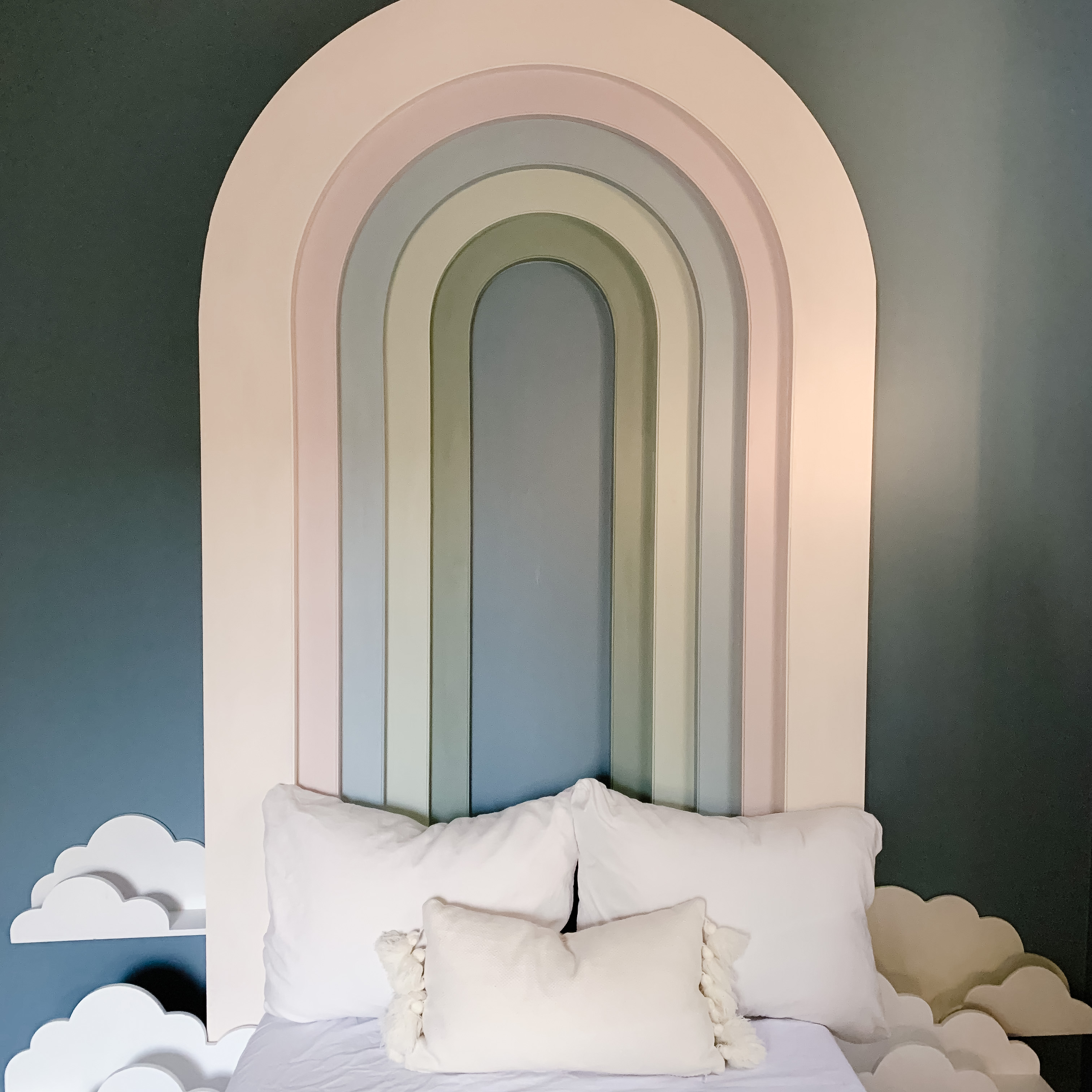 DIY Rainbow Headboard with Cloud Shelves in a blue room.